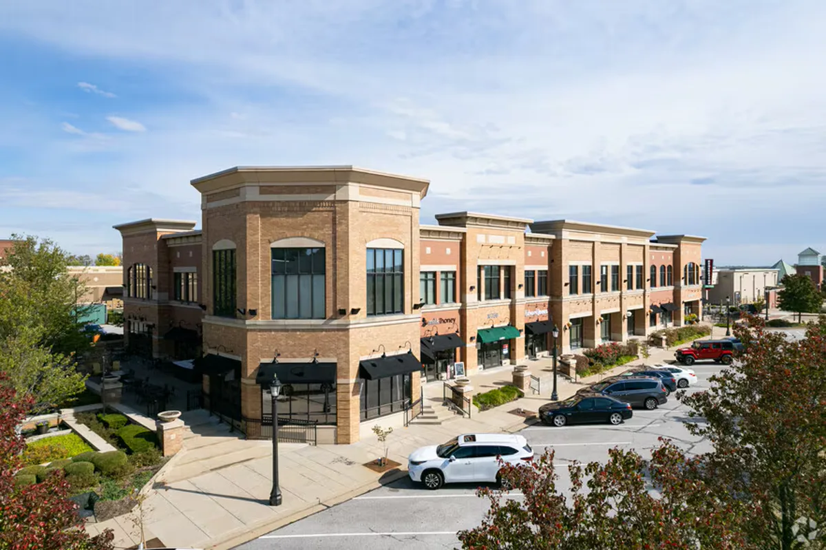 Street-level view of Wildwood Town Center showing brick storefronts, outdoor dining patios, and tree-lined walkways in Wildwood, MO