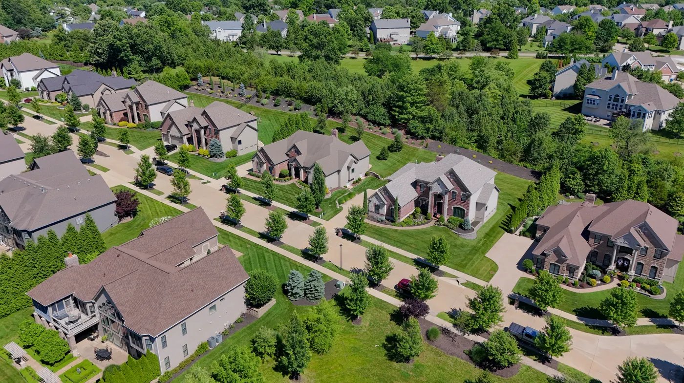 Aerial view of a Wildwood, MO neighborhood with tree-lined streets, large lots, and upscale single-family homes in West St. Louis County